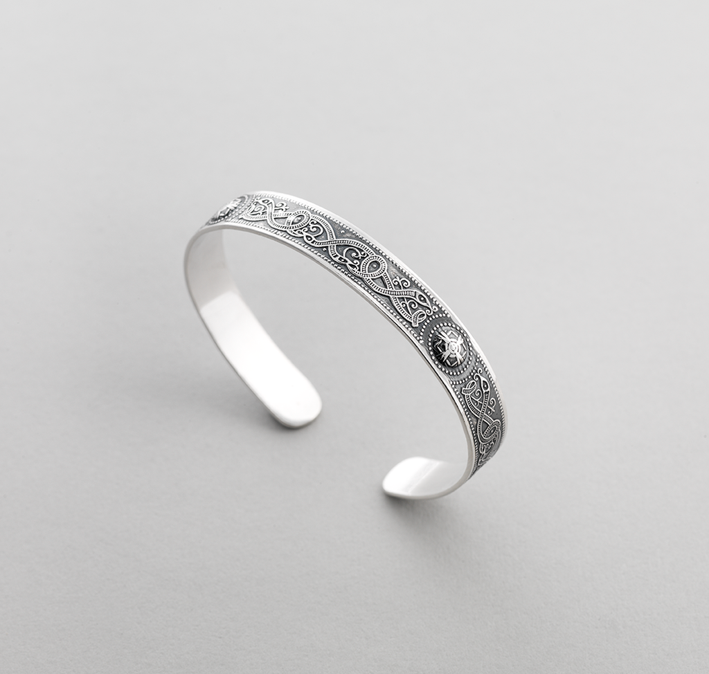 Open Silver bangle with Celtic design of intertwined serpents.